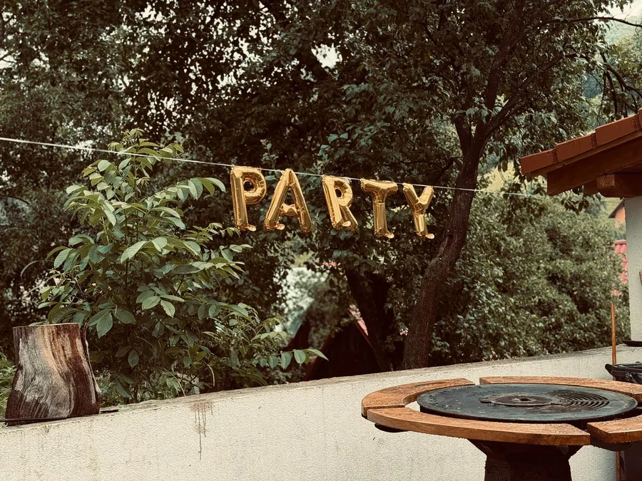 Gold "PARTY" balloon decor by the round grill